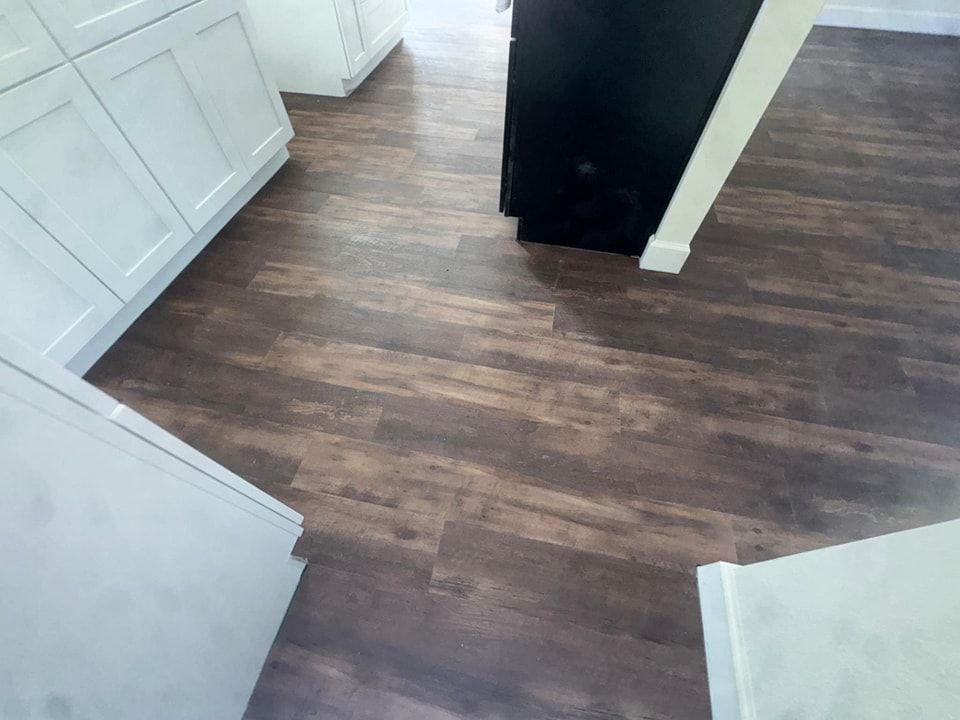 A kitchen with a wooden floor and white cabinets