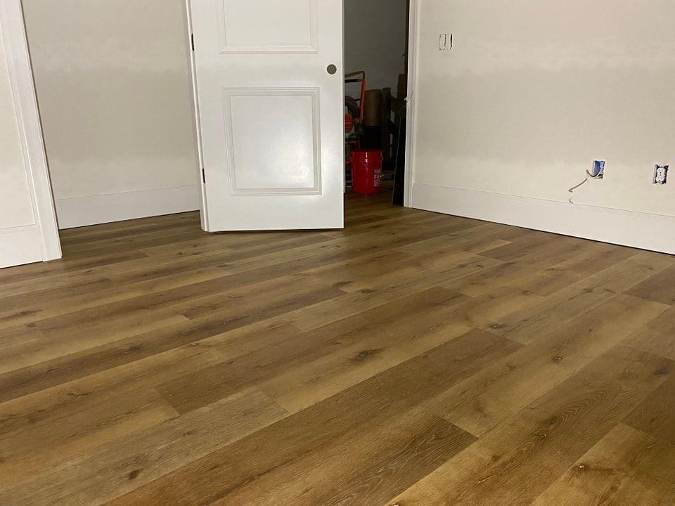 A room with a wooden floor and a white door.