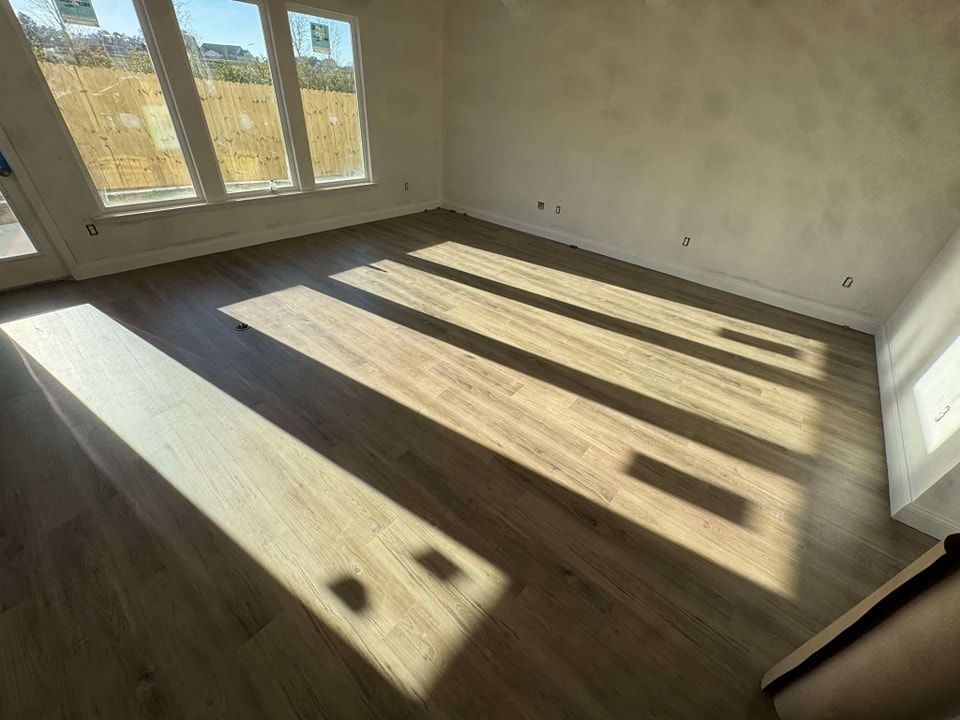 A living room with hardwood floors and a lot of windows.