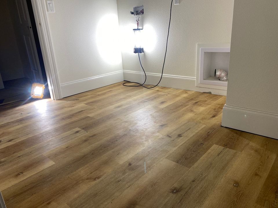 A room with a wooden floor and a light on the floor.