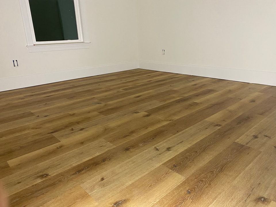 A bedroom with hardwood floors and a window.