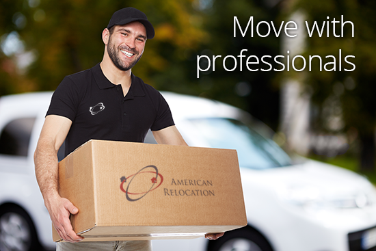 Smiling moving professional carrying a box labeled