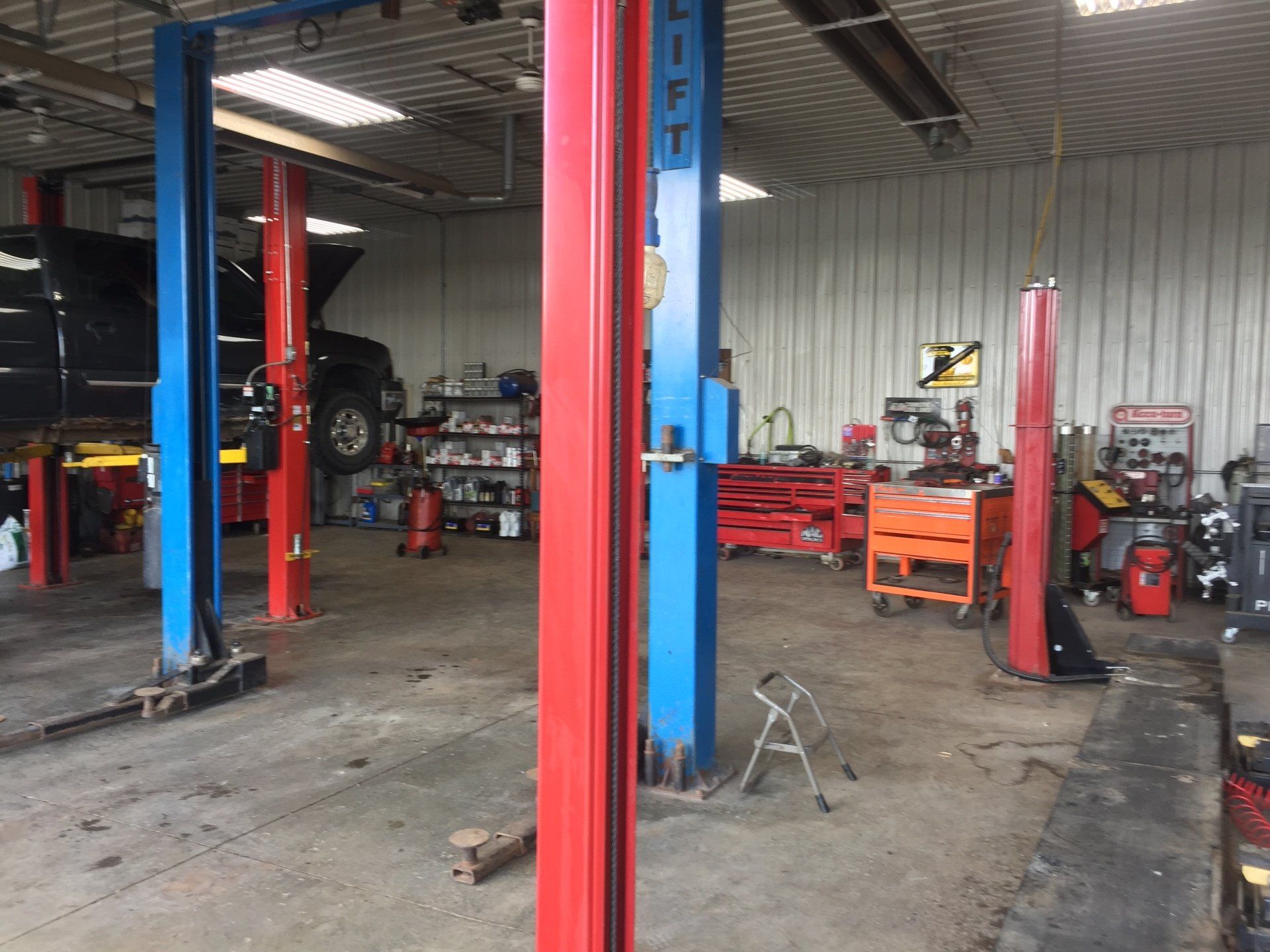 a car is being lifted in a garage with blue and red pillars .