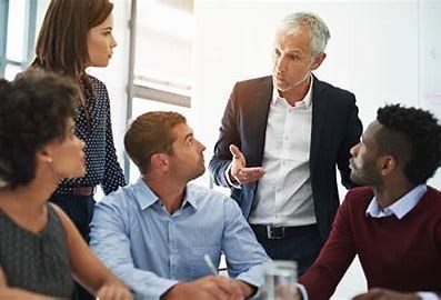 Five employees grouped around leader.