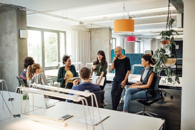 Positive off-boarding is part of a success-focused culture. Employees gathering in meeting with positive energy