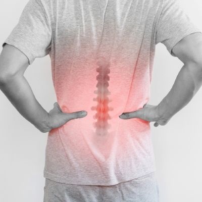 a man is holding his hands on his hips and has back pain .