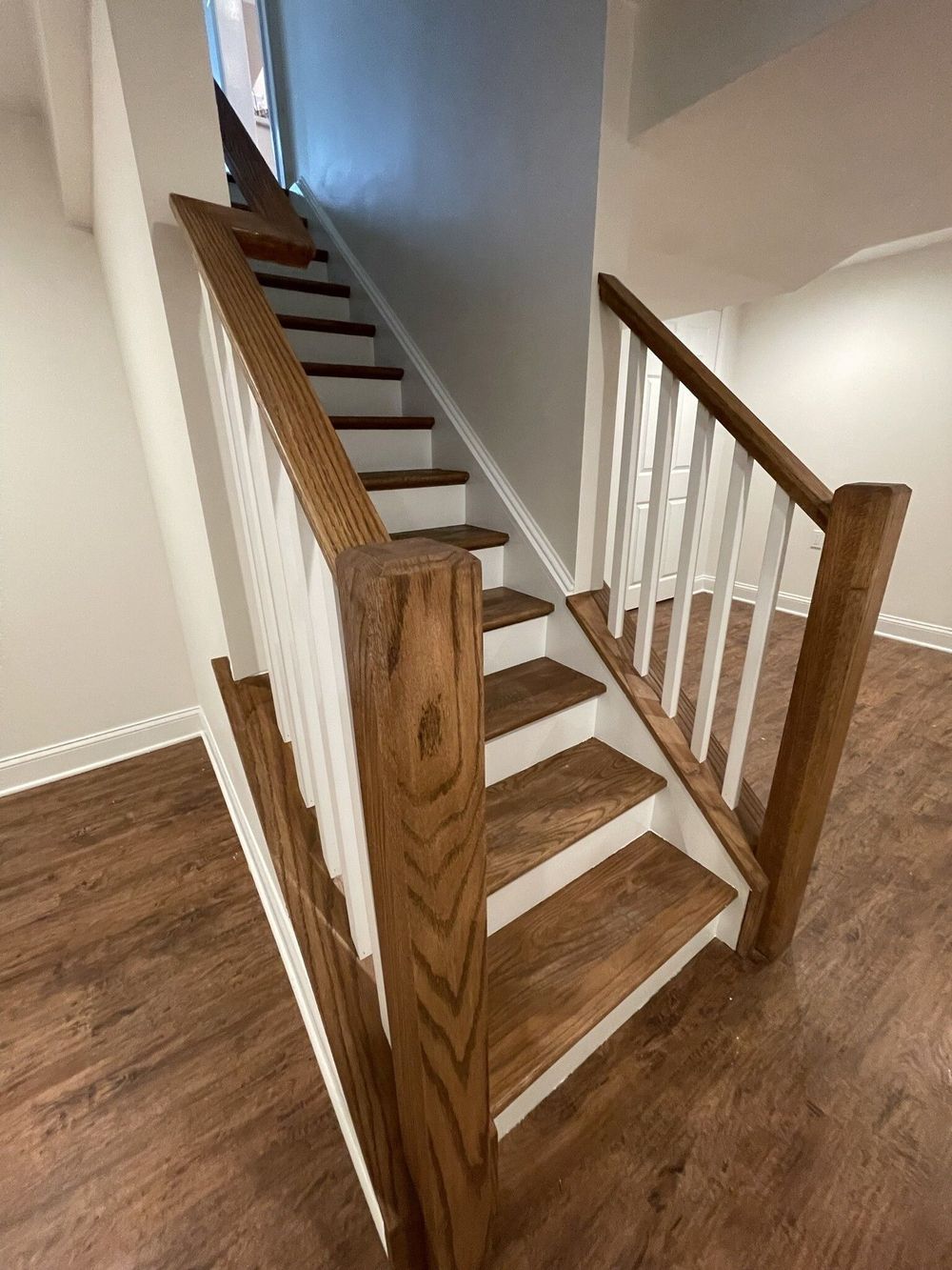 A wooden staircase with a white railing in a house.