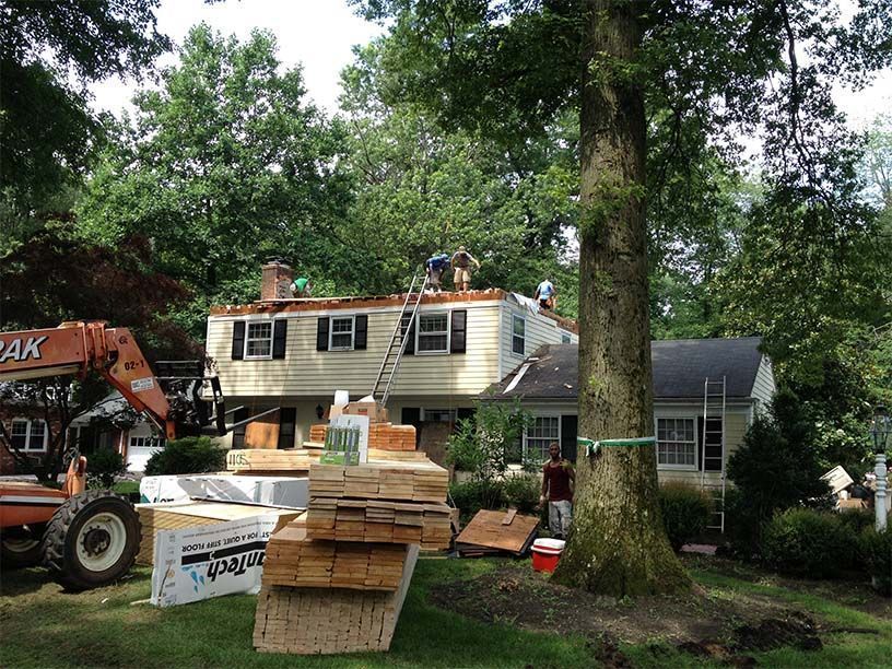 A stack of lumber is sitting in front of a house under construction