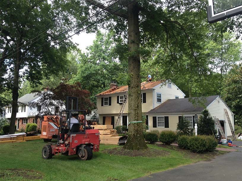 A man is riding a lawn mower in front of a house.