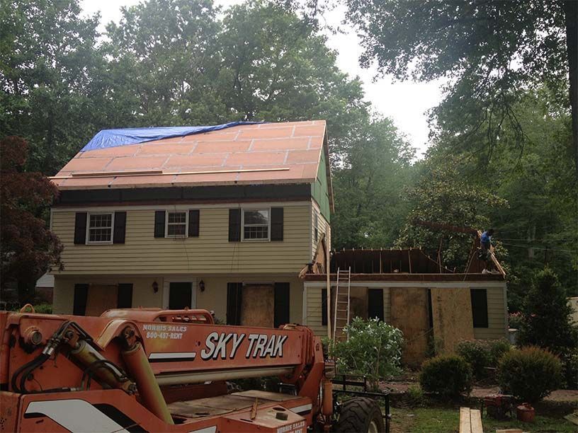 A sky trak truck is parked in front of a house