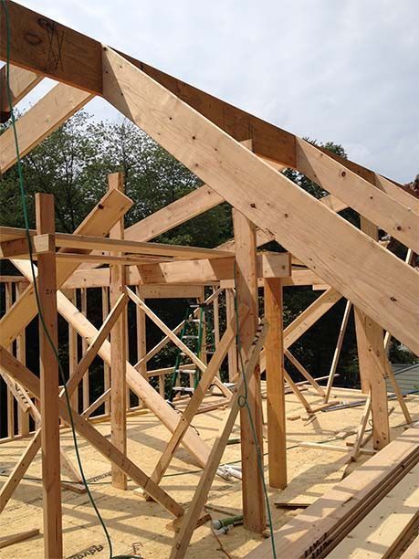 A wooden structure is being built with a ladder in the background