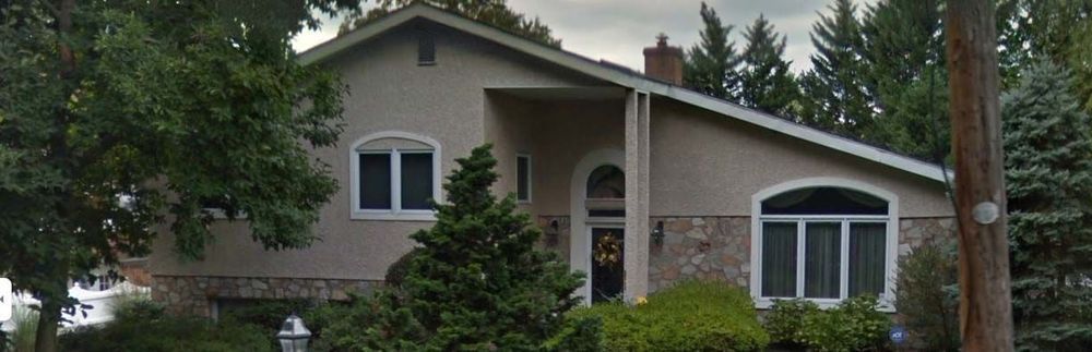 A large house with a lot of windows and trees in front of it.