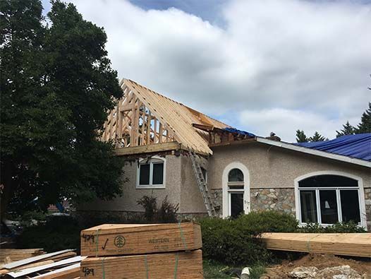 A house is being built with a blue roof.