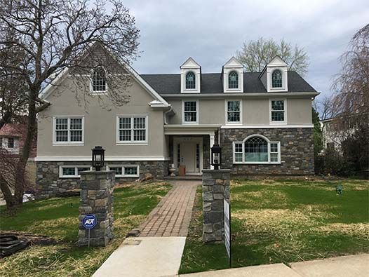 A large house with a brick walkway leading to it.