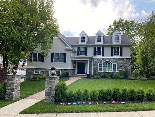 A large house with a lush green lawn in front of it.