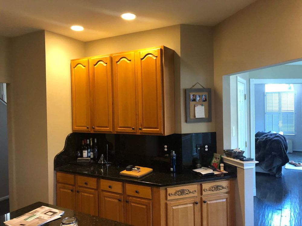 A kitchen with wooden cabinets and black counter tops.