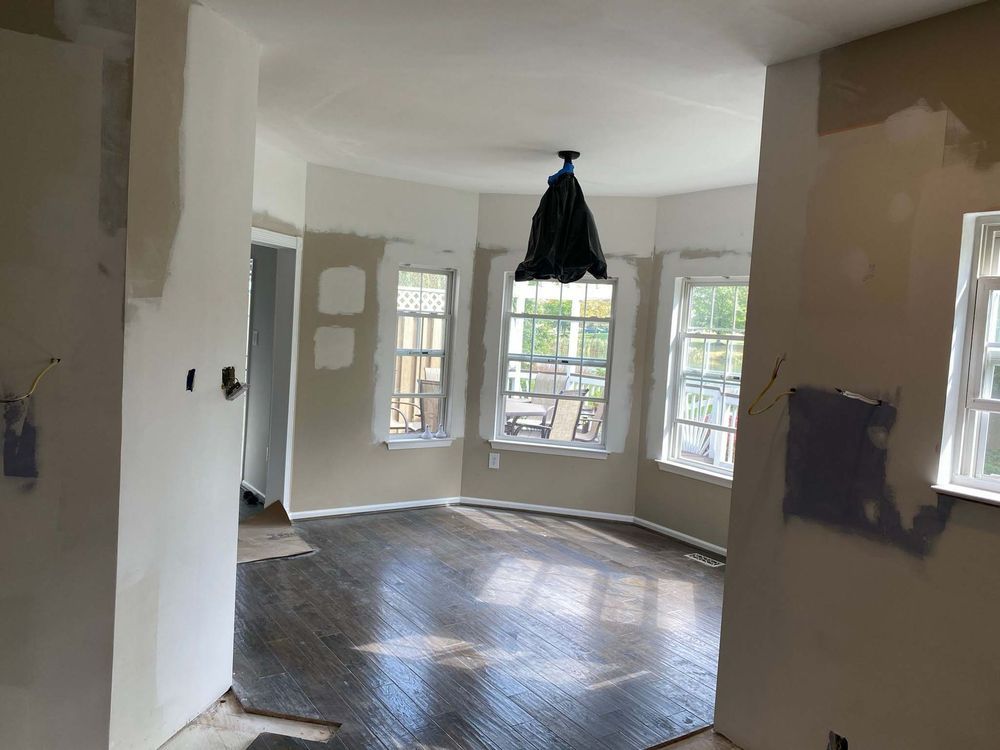 An empty room with a wooden floor and a ceiling fan.
