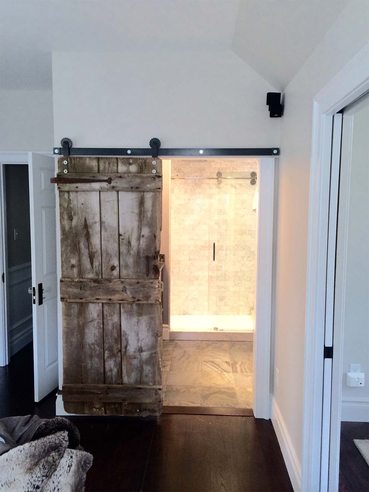 A sliding barn door leads to a bathroom