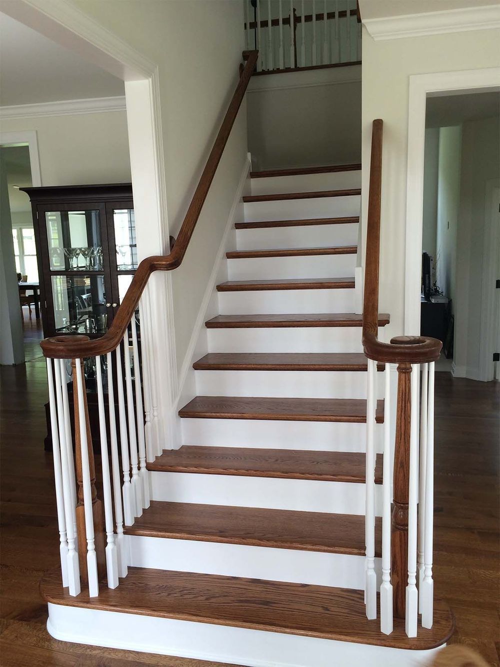 A wooden staircase with white railings in a house