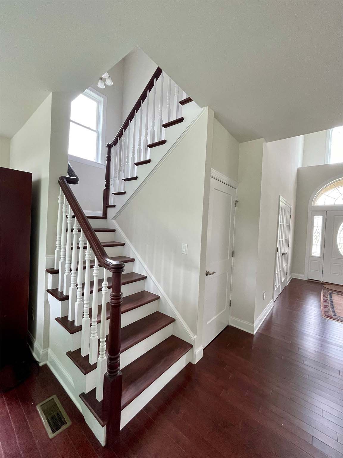 A staircase in a house with wooden steps and a white railing.
