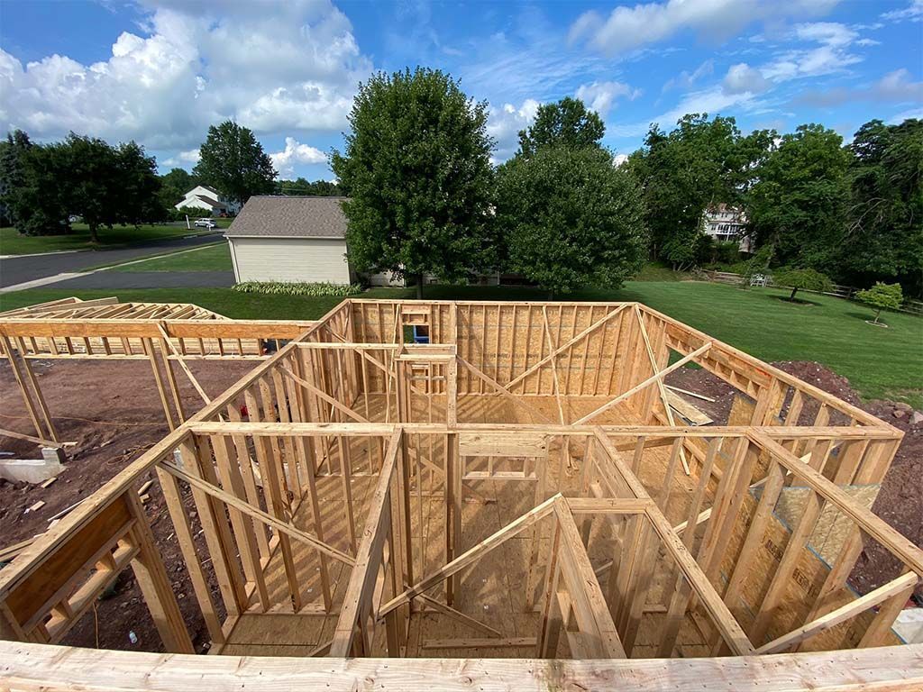 A wooden house is being built in a residential area.