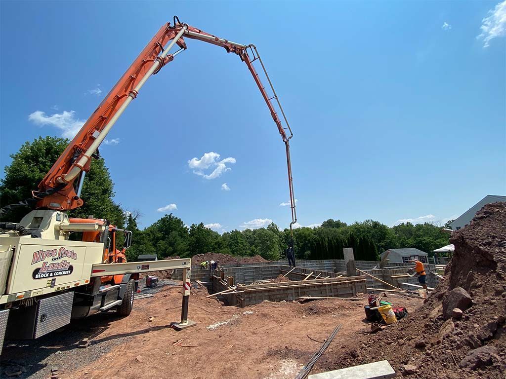 A concrete pump is being used to pour concrete on a construction site.