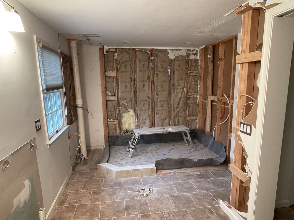 A room with a ladder in the middle of it is being remodeled.