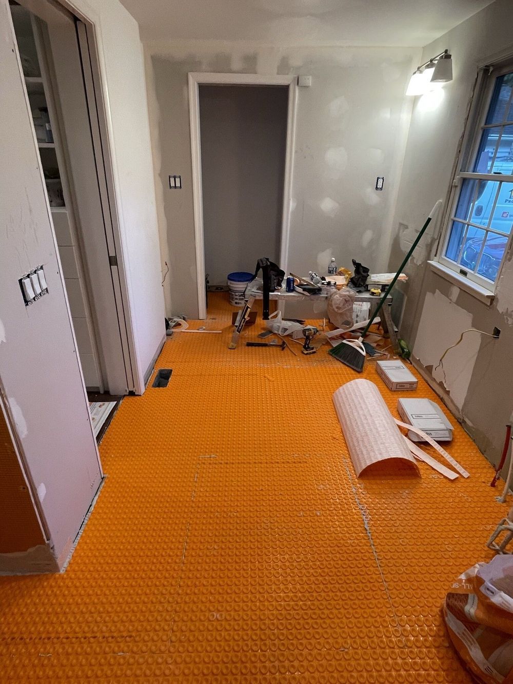 A room with a yellow mat on the floor and a window.