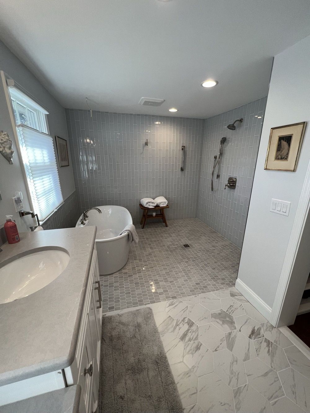 A bathroom with a tub , sink , and walk in shower.