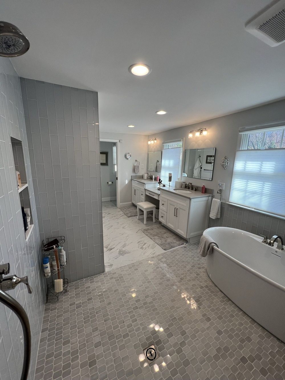 A bathroom with a tub , sink , mirror and shower.