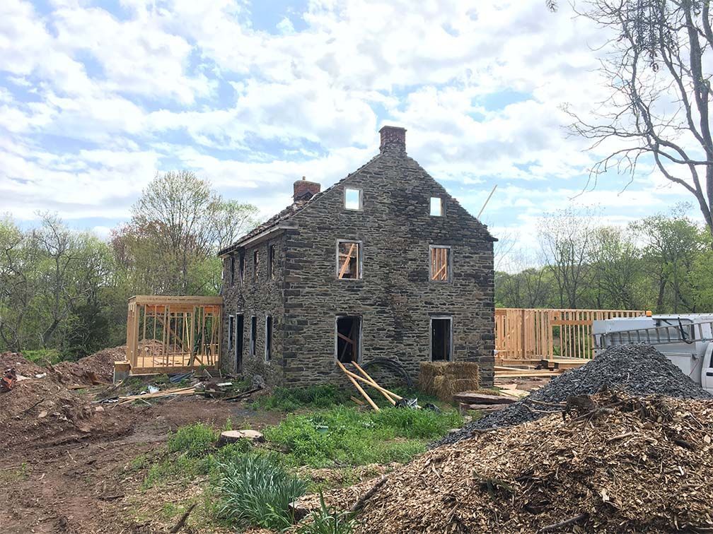 A large stone house is being built in the middle of a dirt field.