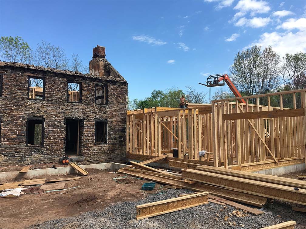 A large brick building is being built with wooden beams.