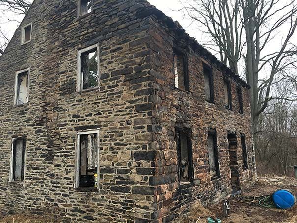 An old brick building with a lot of windows and trees in the background