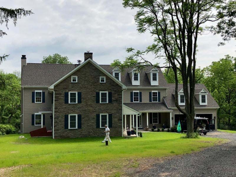 A large house with a lot of windows is surrounded by trees