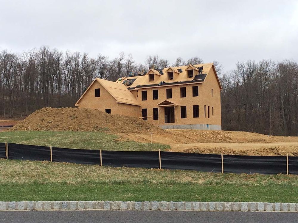 A large house is being built in the middle of a field