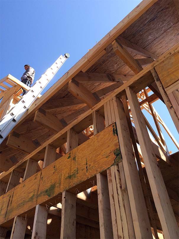 A man standing on top of a wooden structure with a ladder