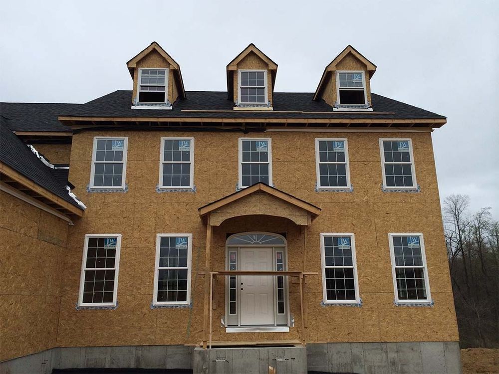A large house with a lot of windows is under construction