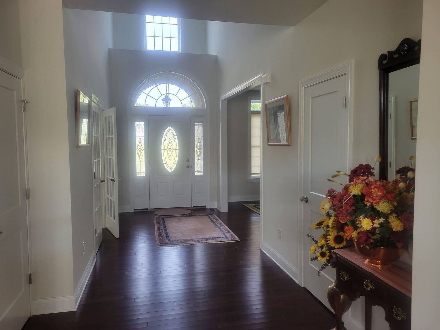 A hallway in a house with a vase of flowers on a table.