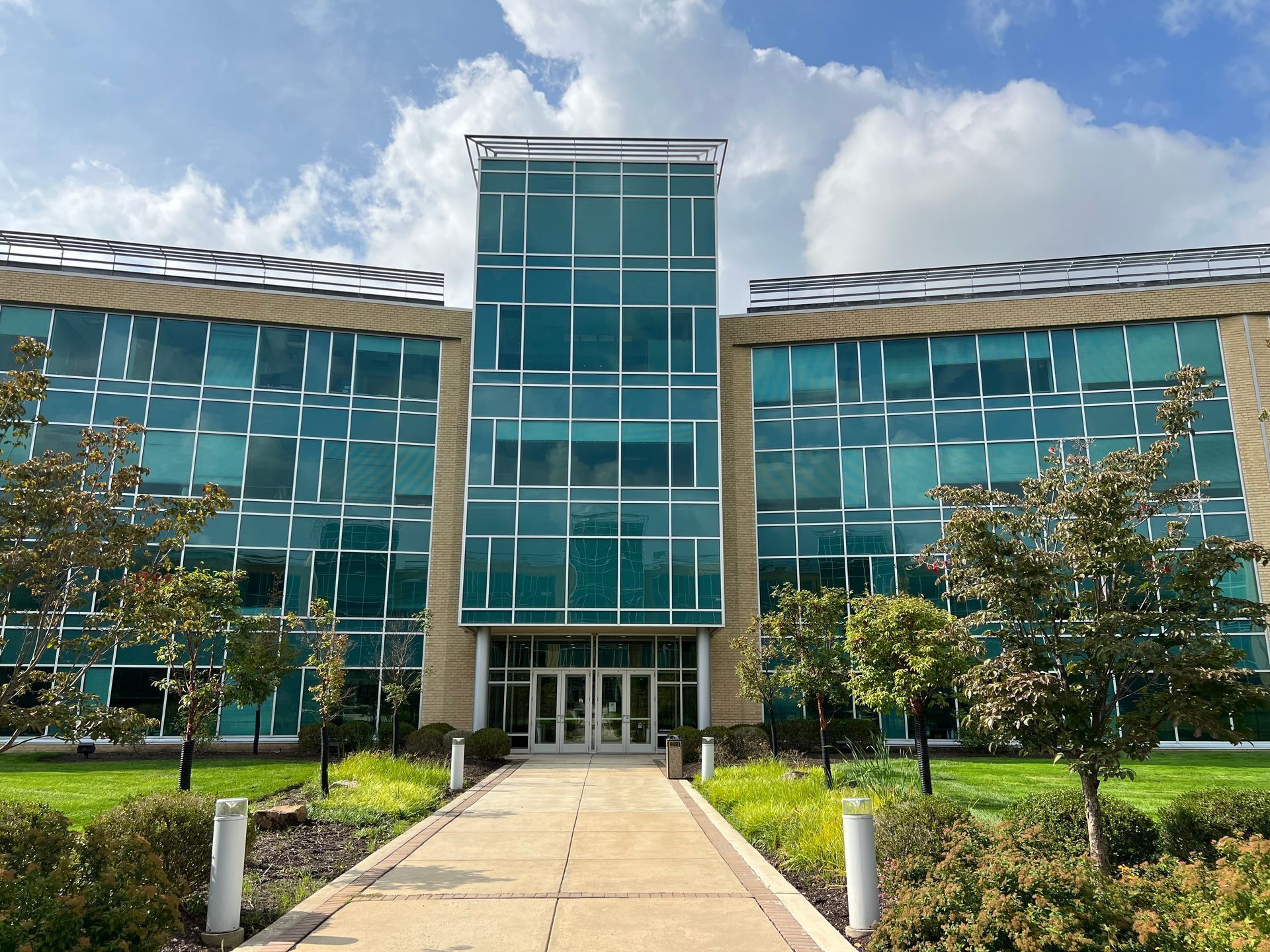 A large building with a lot of windows and trees in front of it