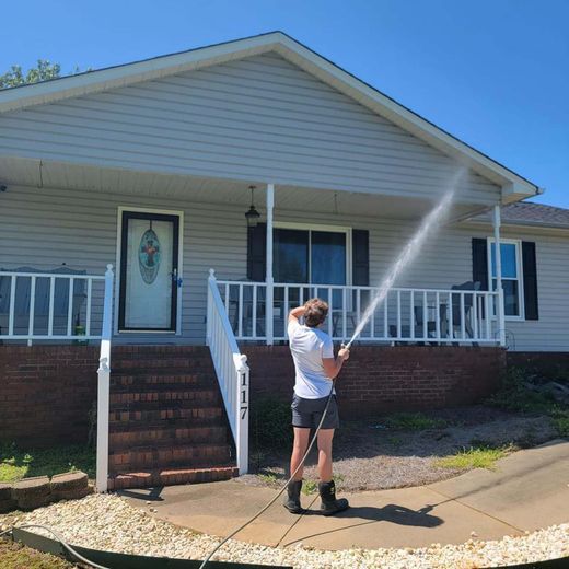 A man is spraying a house with a hose