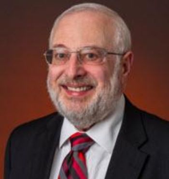 A man with a beard is wearing a blue suit and a bow tie.