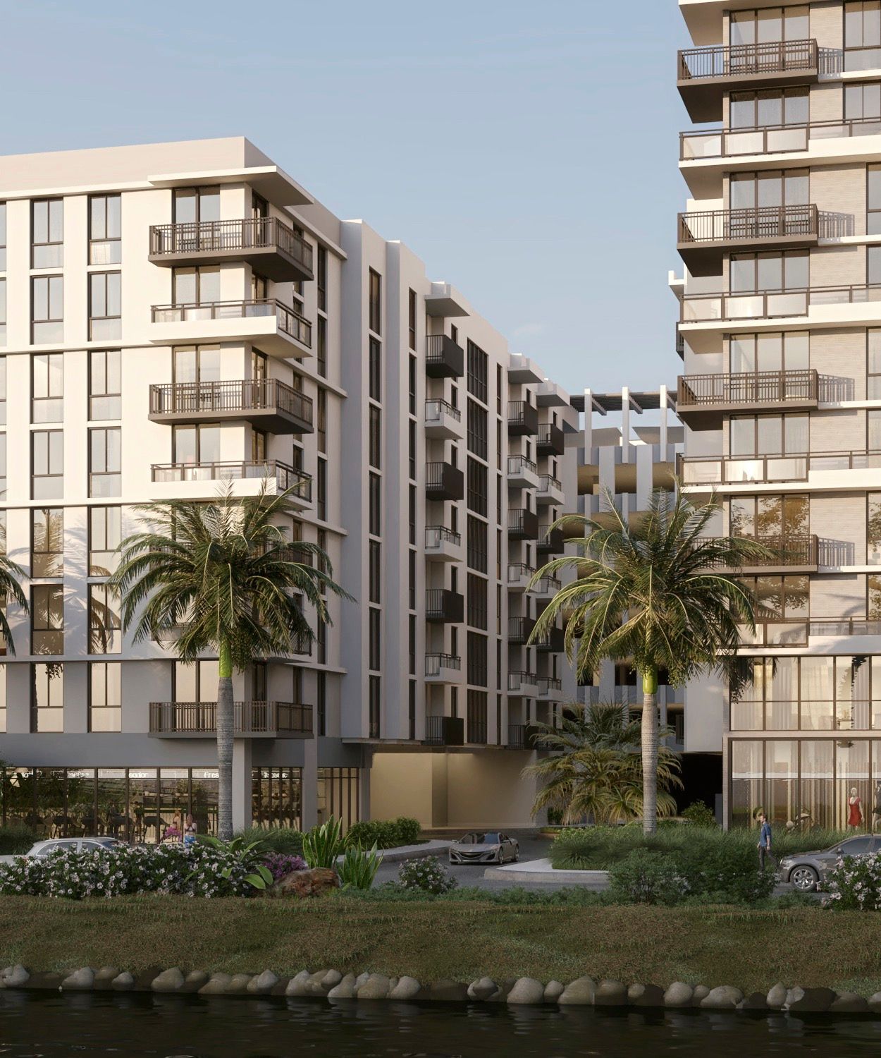 Modern apartment buildings with balconies, palm trees, and a water feature.
