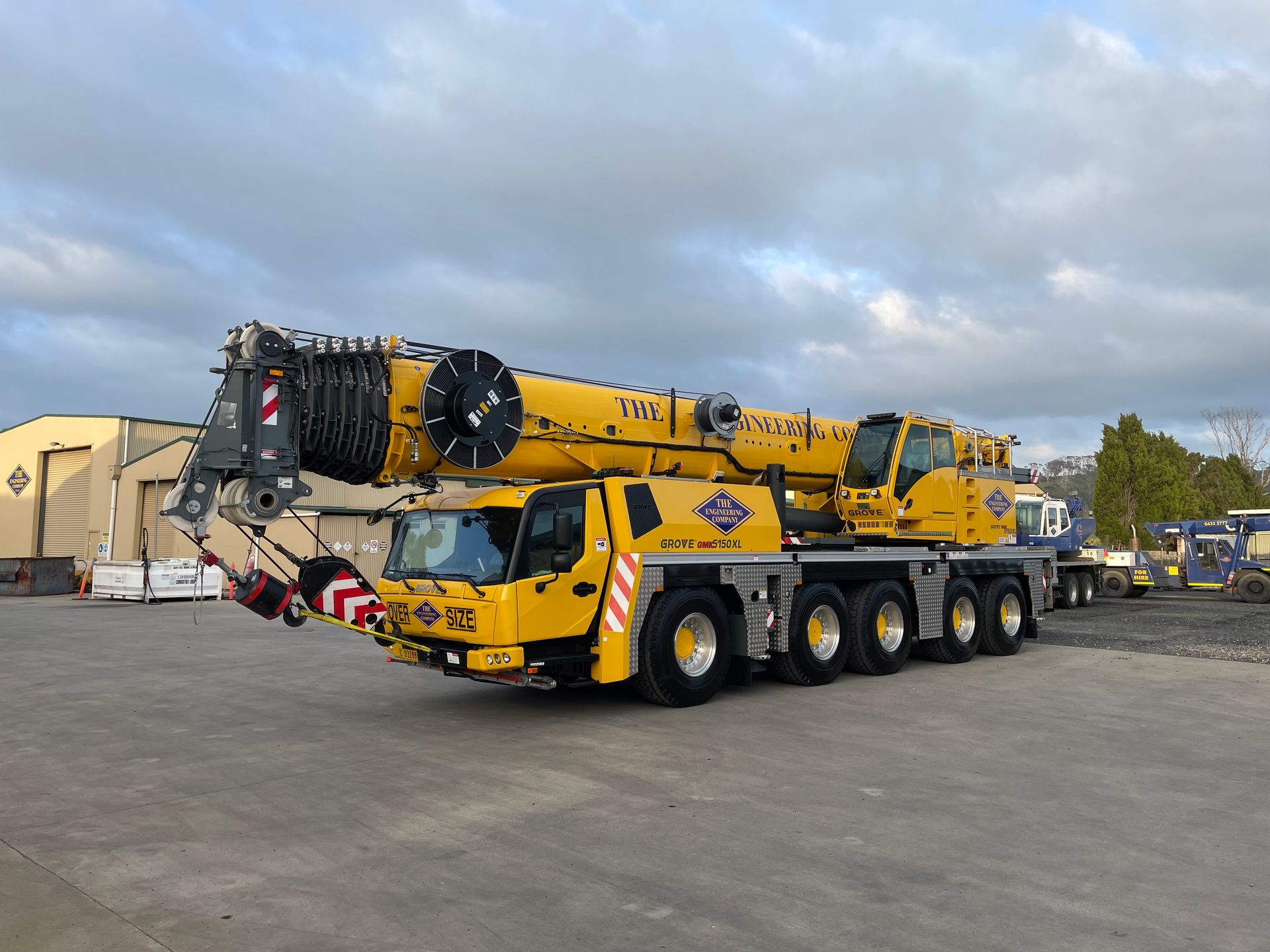 Yellow mobile crane parked on concrete.