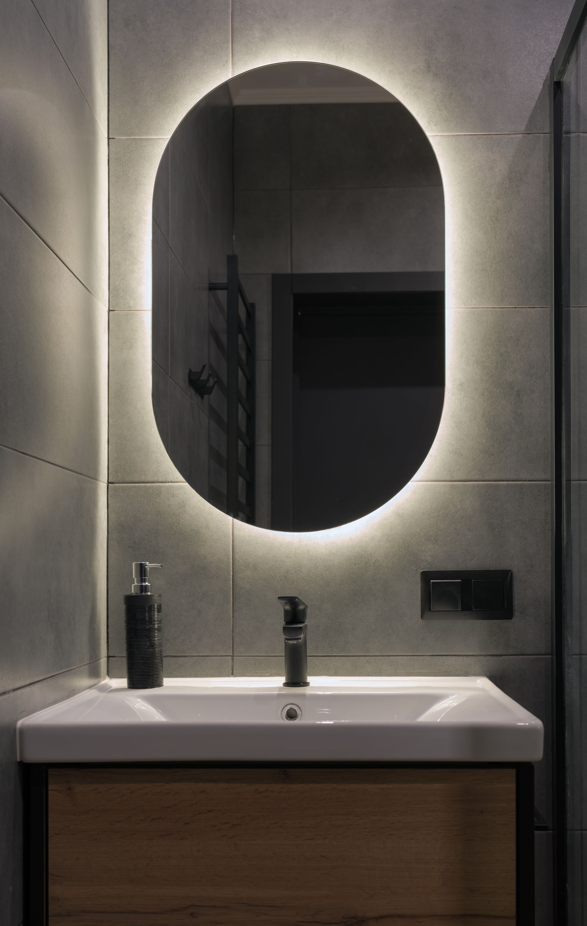 A bathroom with a sink and a round mirror.