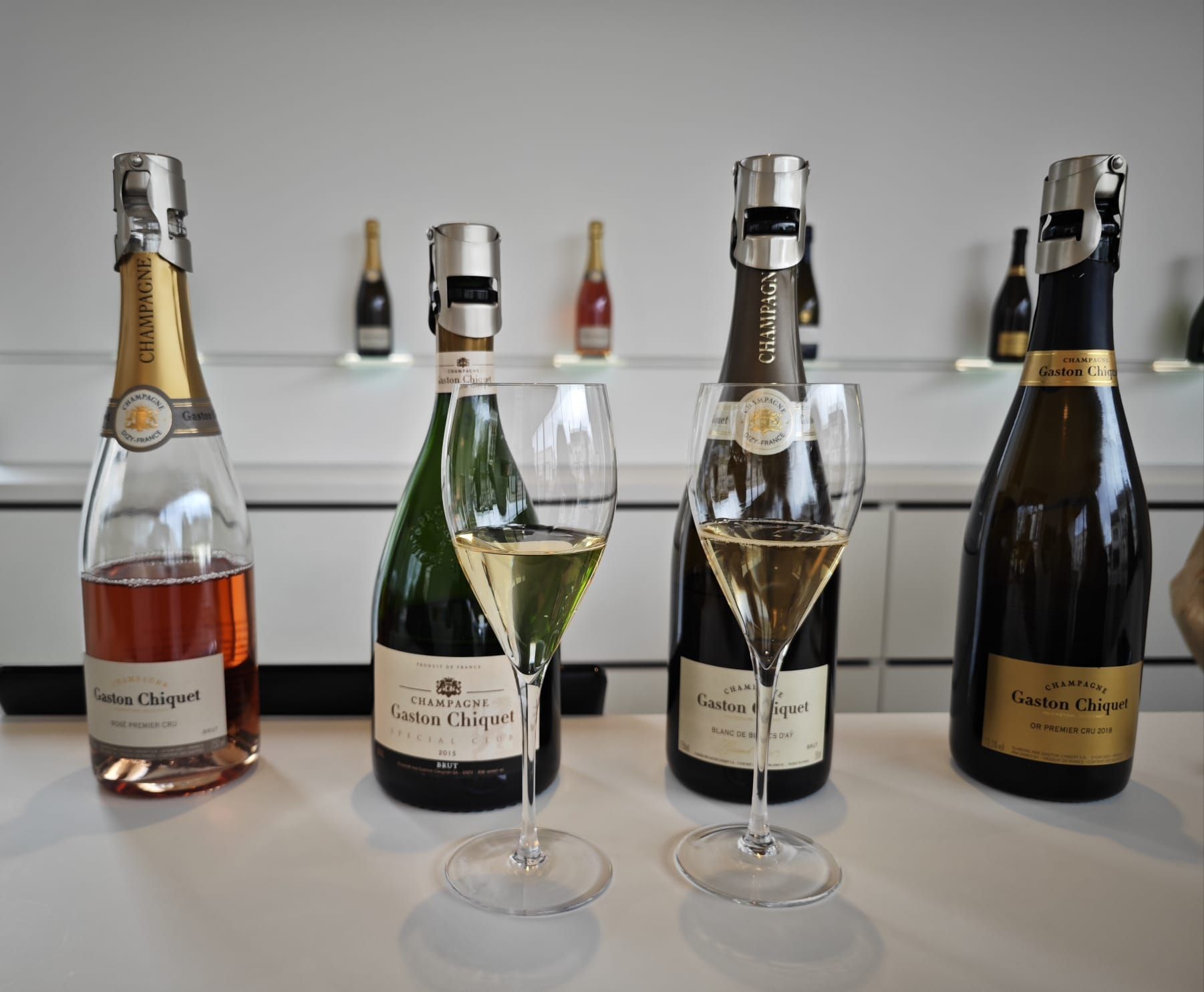 Vue intérieure d'un van de luxe avec sièges en cuir noir, éclairage d'ambiance et fenêtres donnant sur une forêt.