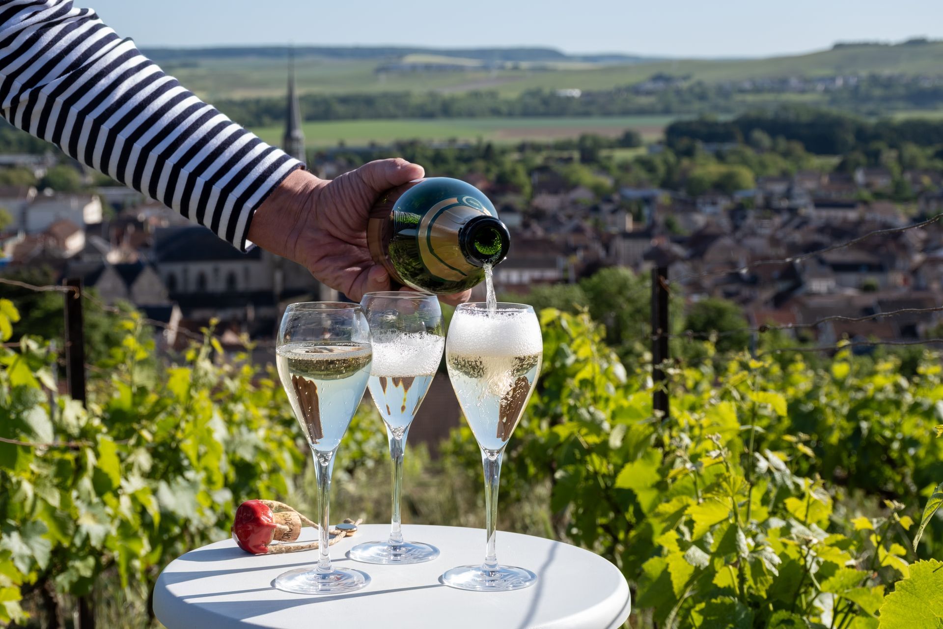 Deux hommes en costume se trouvent à côté d'une voiture noire à portes papillon, devant un bâtiment à porte cintrée.