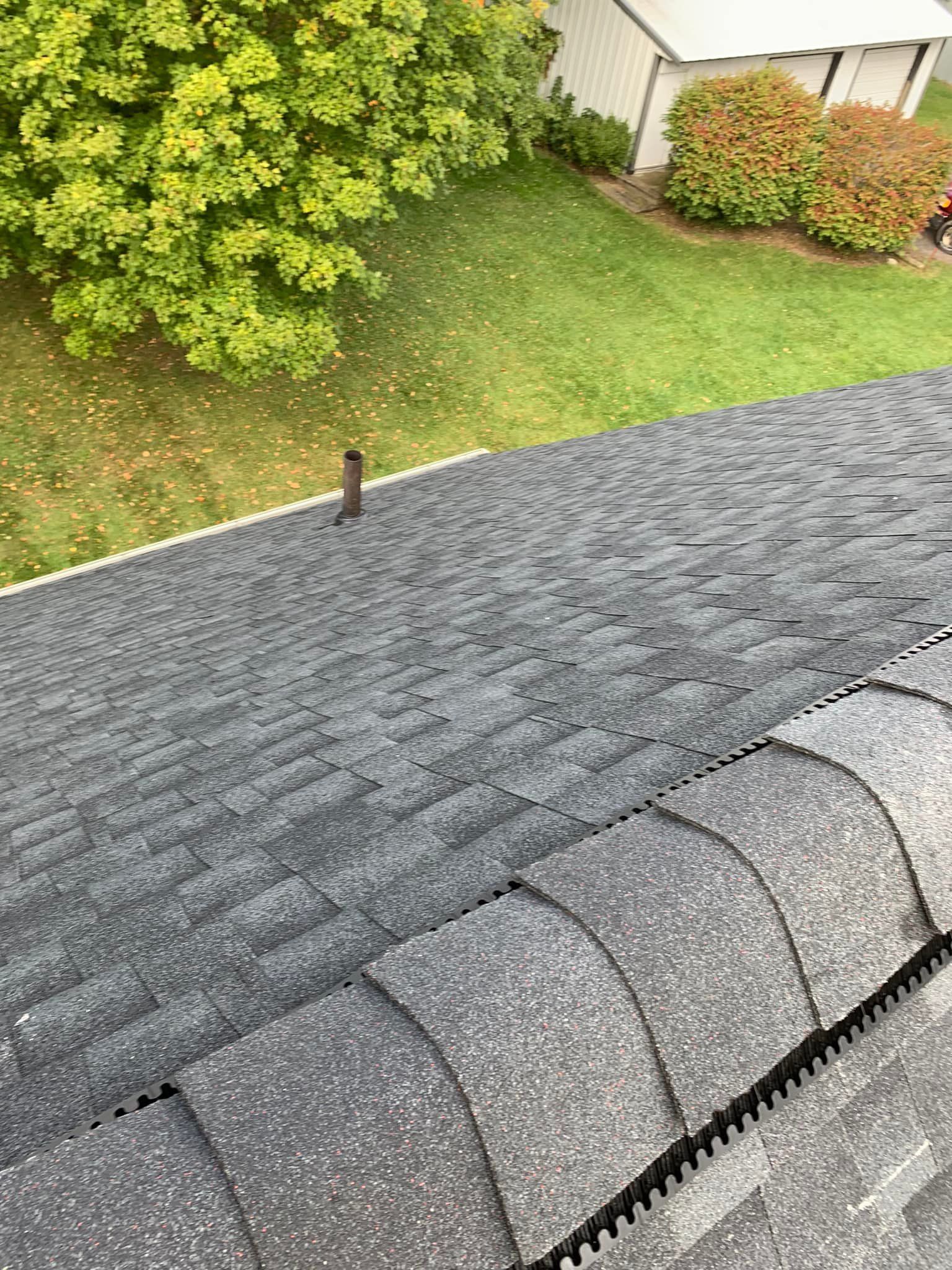 A large gray house with a black roof