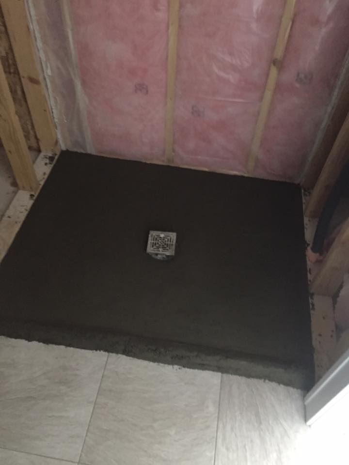 A concrete shower stall is being built in a bathroom.