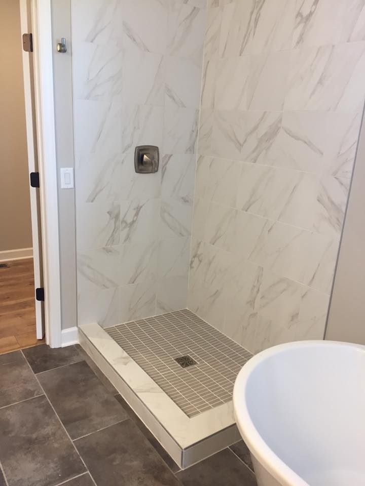 A bathroom with a walk in shower and a bathtub.