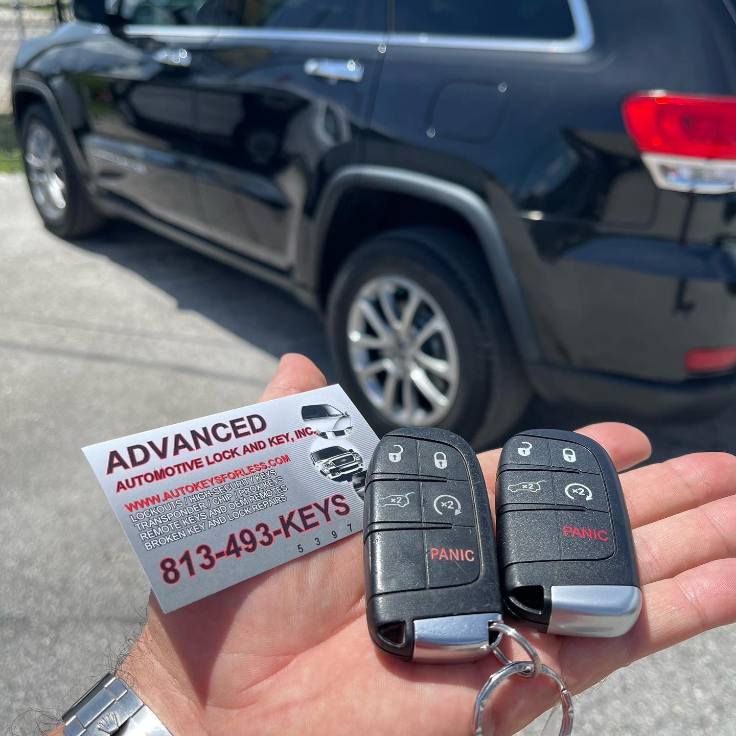 A person is holding a card that says advanced automotive lock and key